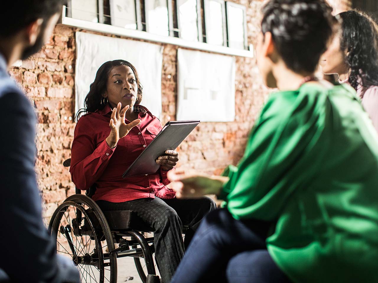 Woman in wheelchair talking to coworkers